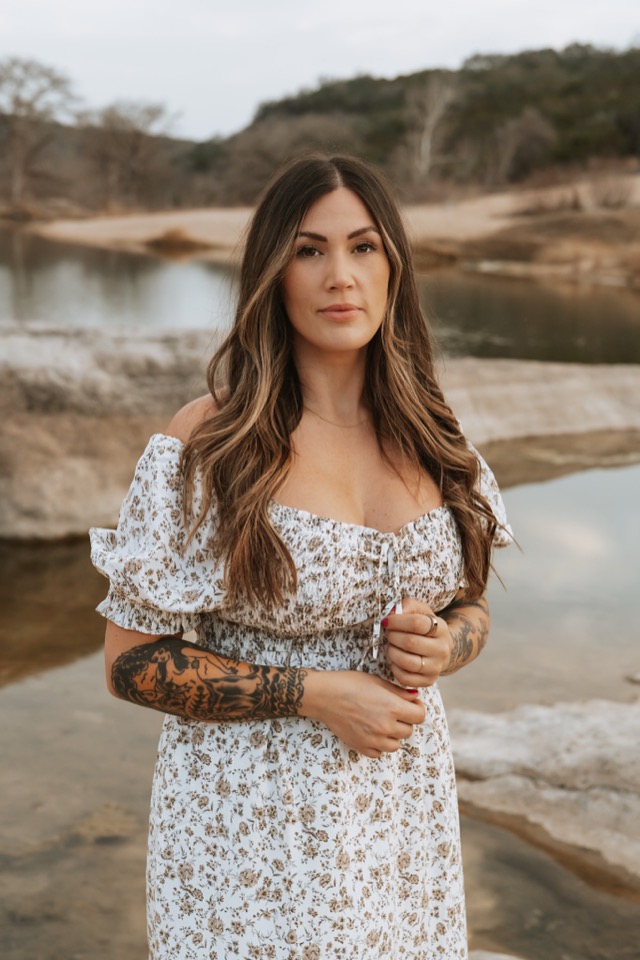 Expecting mother in floral dress by the water